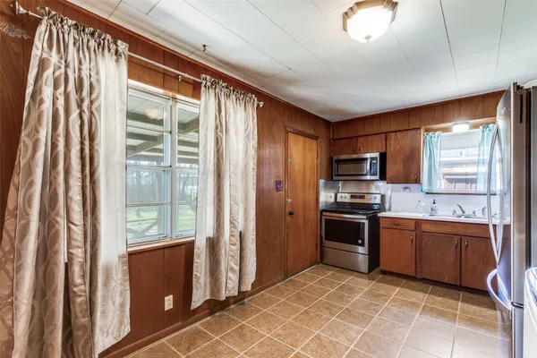 a kitchen with stainless steel appliances granite countertop a refrigerator and a sink