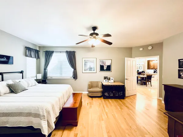 a spacious bedroom with a bed and wooden floor