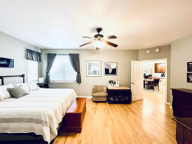 a spacious bedroom with a bed and wooden floor