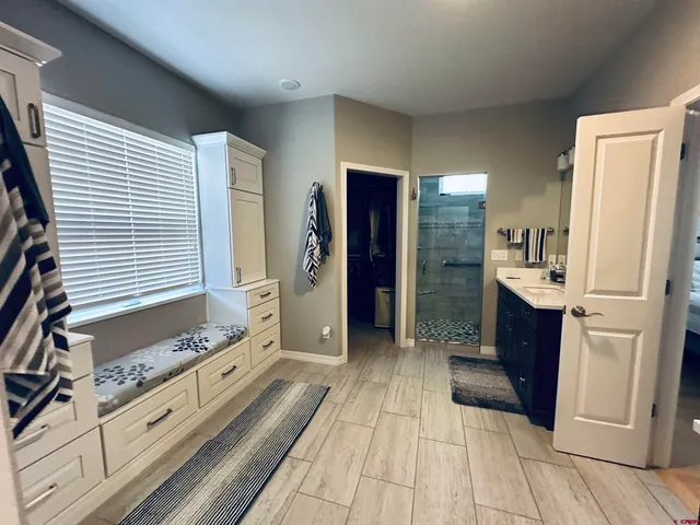 a large bathroom with a double vanity sink a large mirror and a shower