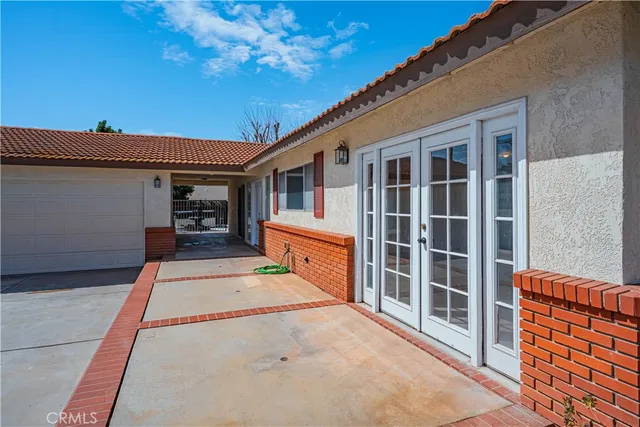 a backyard of a house with barbeque oven and outdoor seating