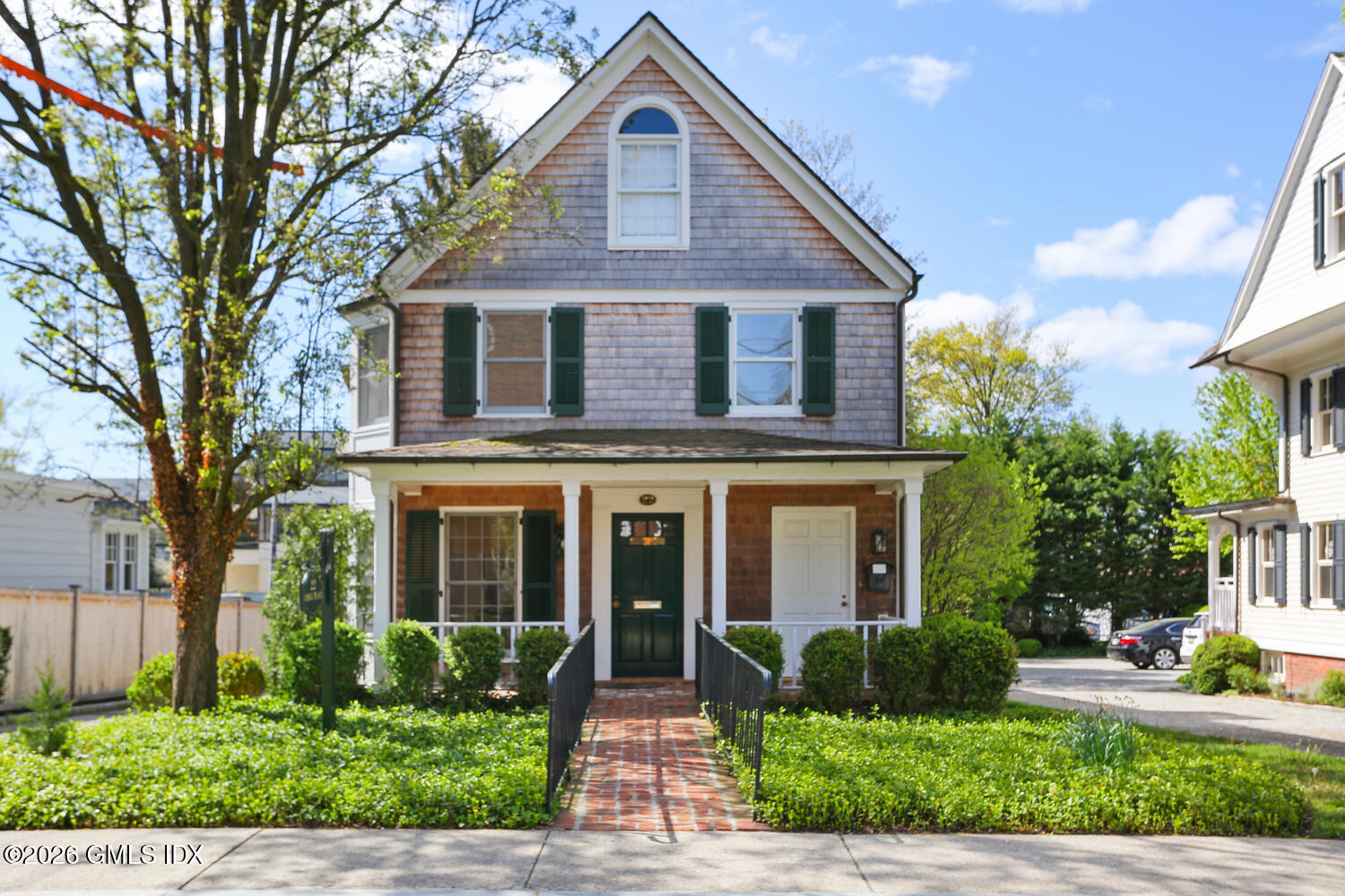 22 Grigg Street, Unit 2 Greenwich, CT 06830 - Photo 1 of 11 a front view of a house with a yard and potted plants
