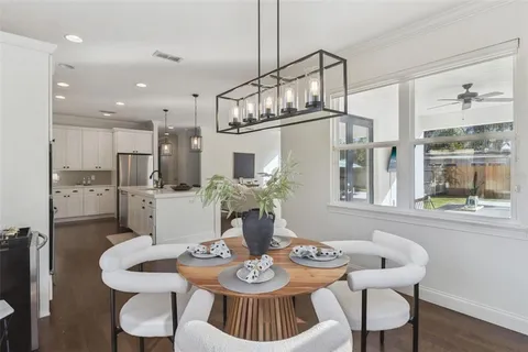 a view of a dining room with furniture a kitchen and chandelier