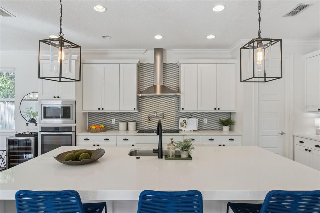 5018 Monet Avenue Belle Isle, FL 32812 - Photo 19 of 56 a kitchen with a sink a stove and chairs with wooden floor