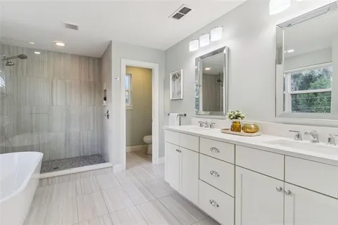 a spacious bedroom with a bed and a chandelier