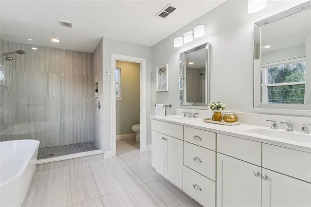 a spacious bedroom with a bed and a chandelier