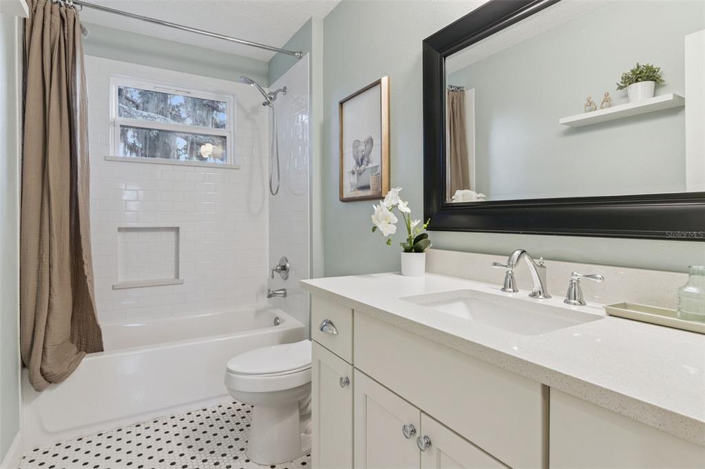 5018 Monet Avenue Belle Isle, FL 32812 - Photo 36 of 56 a bathroom with a granite countertop sink toilet a mirror a vanity a bath tub and shower