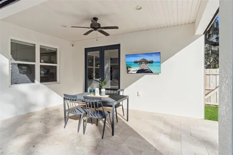 a view of a patio with a table chairs and a floor to ceiling window