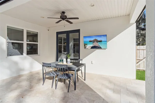 a view of a patio with a table chairs and a floor to ceiling window