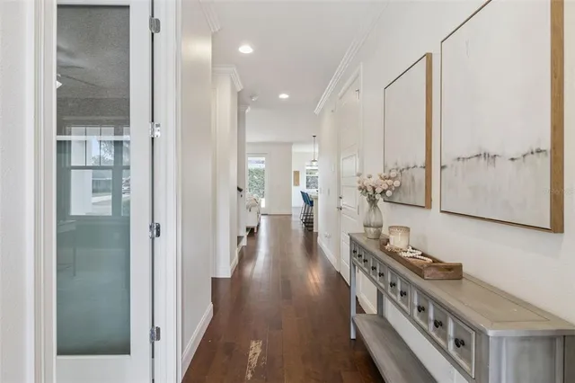 a view of a hallway with wooden floor and windows