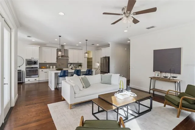 a living room with furniture kitchen view and a flat screen tv