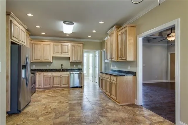 a large kitchen with stainless steel appliances a refrigerator and a stove top oven