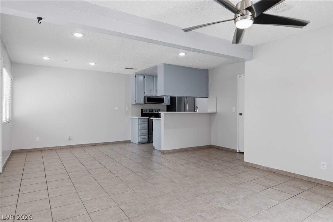 An inviting open-concept living area seamlessly connects to a kitchen featuring a breakfast bar.