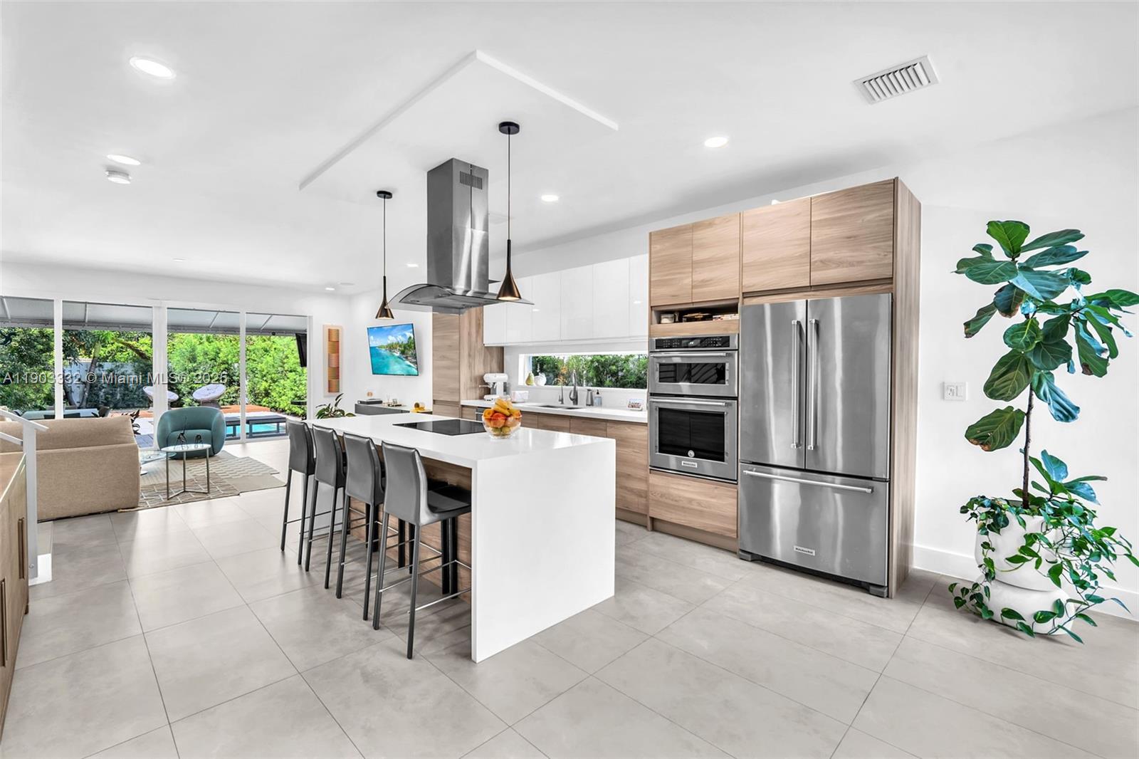 3167 Southwest 25th Street, Unit 1 Miami, FL 33133 - Photo 11 of 42 a kitchen with refrigerator and chairs