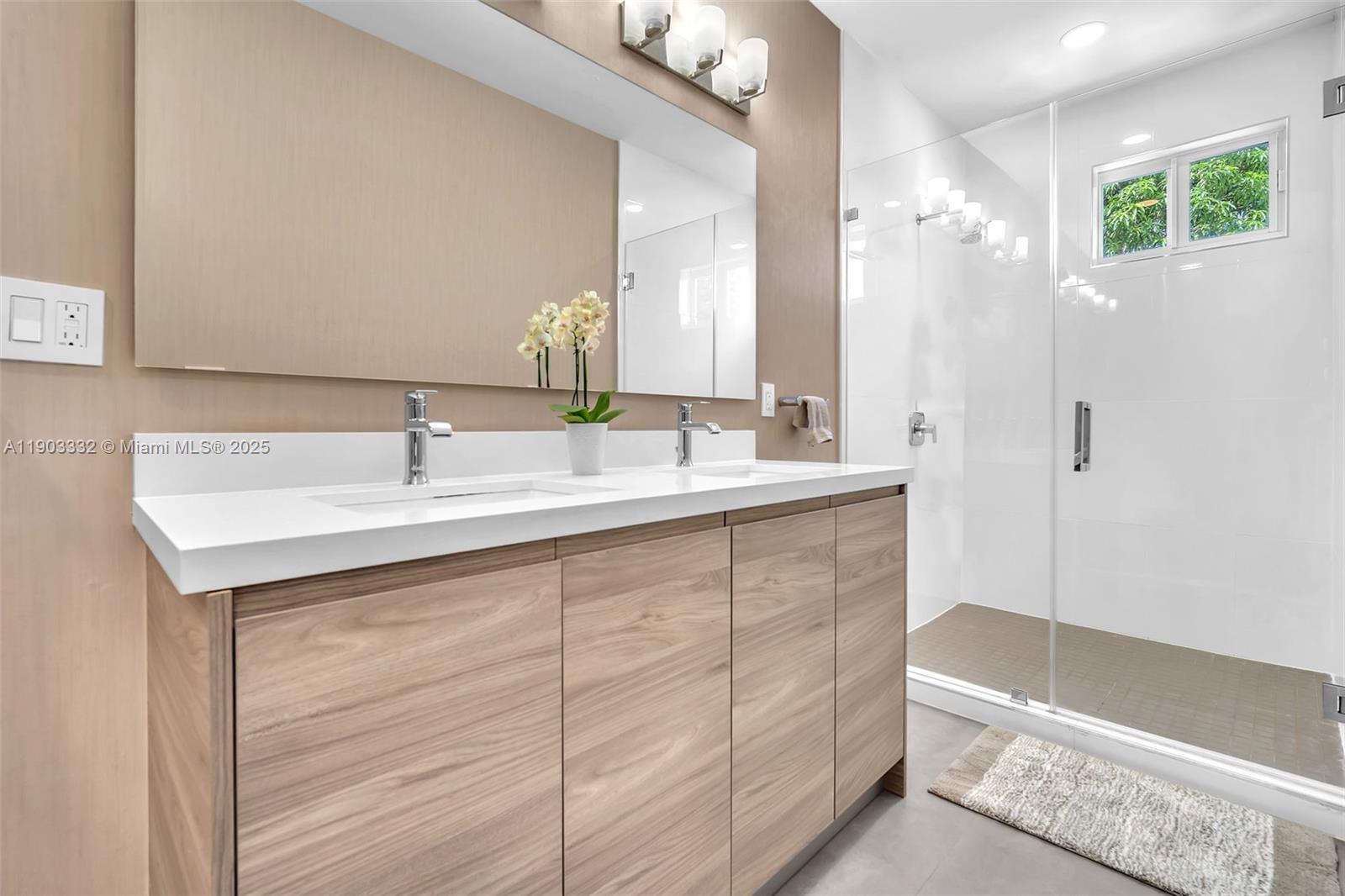 3167 Southwest 25th Street, Unit 1 Miami, FL 33133 - Photo 33 of 42 a bathroom with a double vanity sink a mirror a bathtub and shower