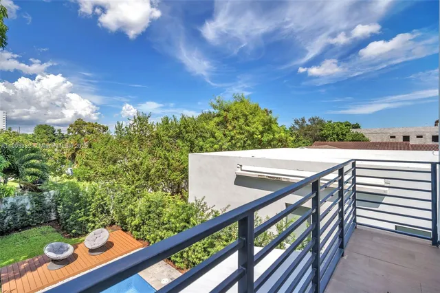 a view of yard from deck with patio