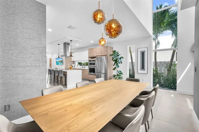 a kitchen with stainless steel appliances kitchen island granite countertop a table and chairs in it