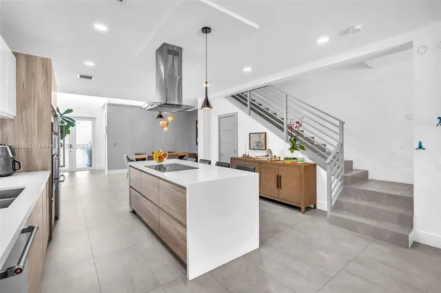 a kitchen with stainless steel appliances granite countertop a sink and a large window