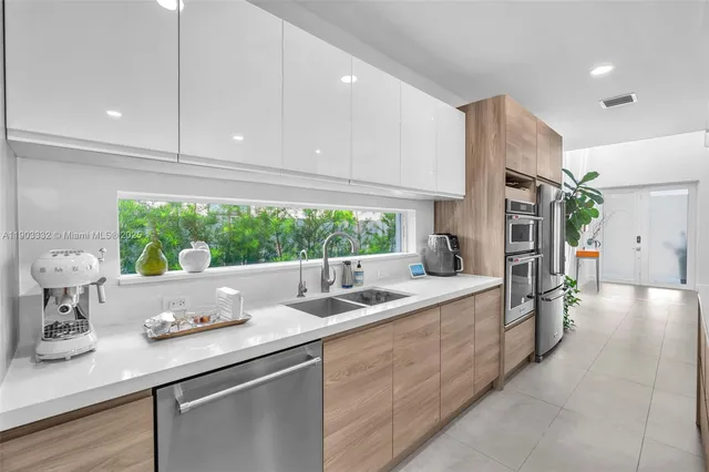 a kitchen with refrigerator and chairs