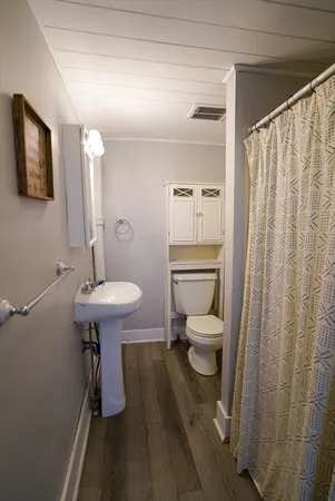 a bathroom with a sink a toilet and shower