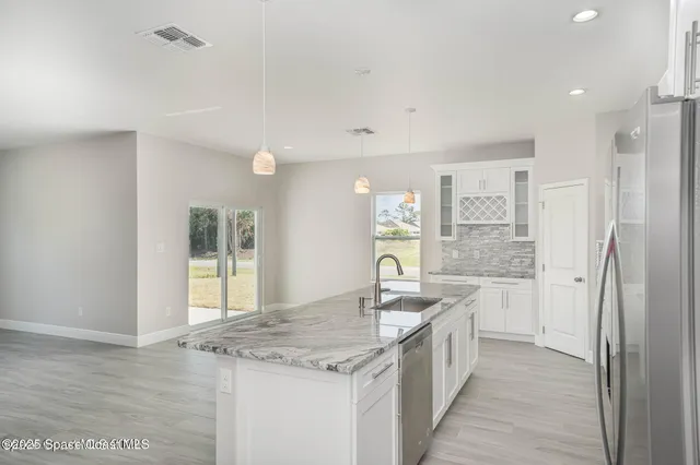 a kitchen with granite countertop a sink stove and refrigerator