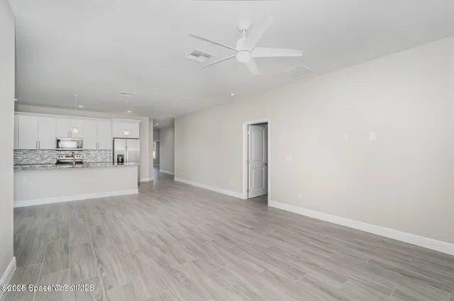 a view of a kitchen with wooden floor and window