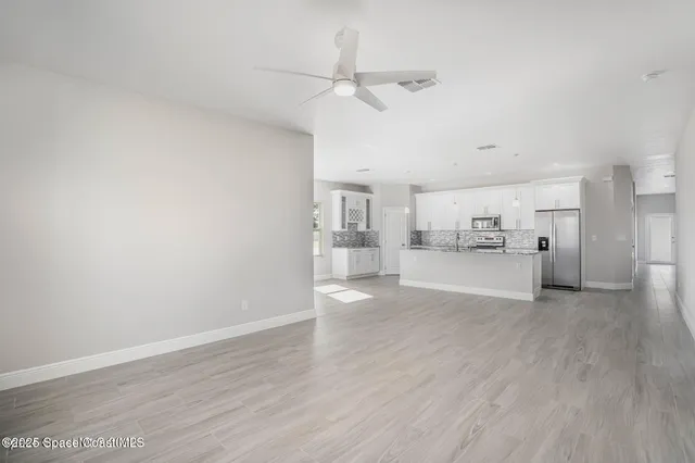 a view of a kitchen with wooden floor and windows