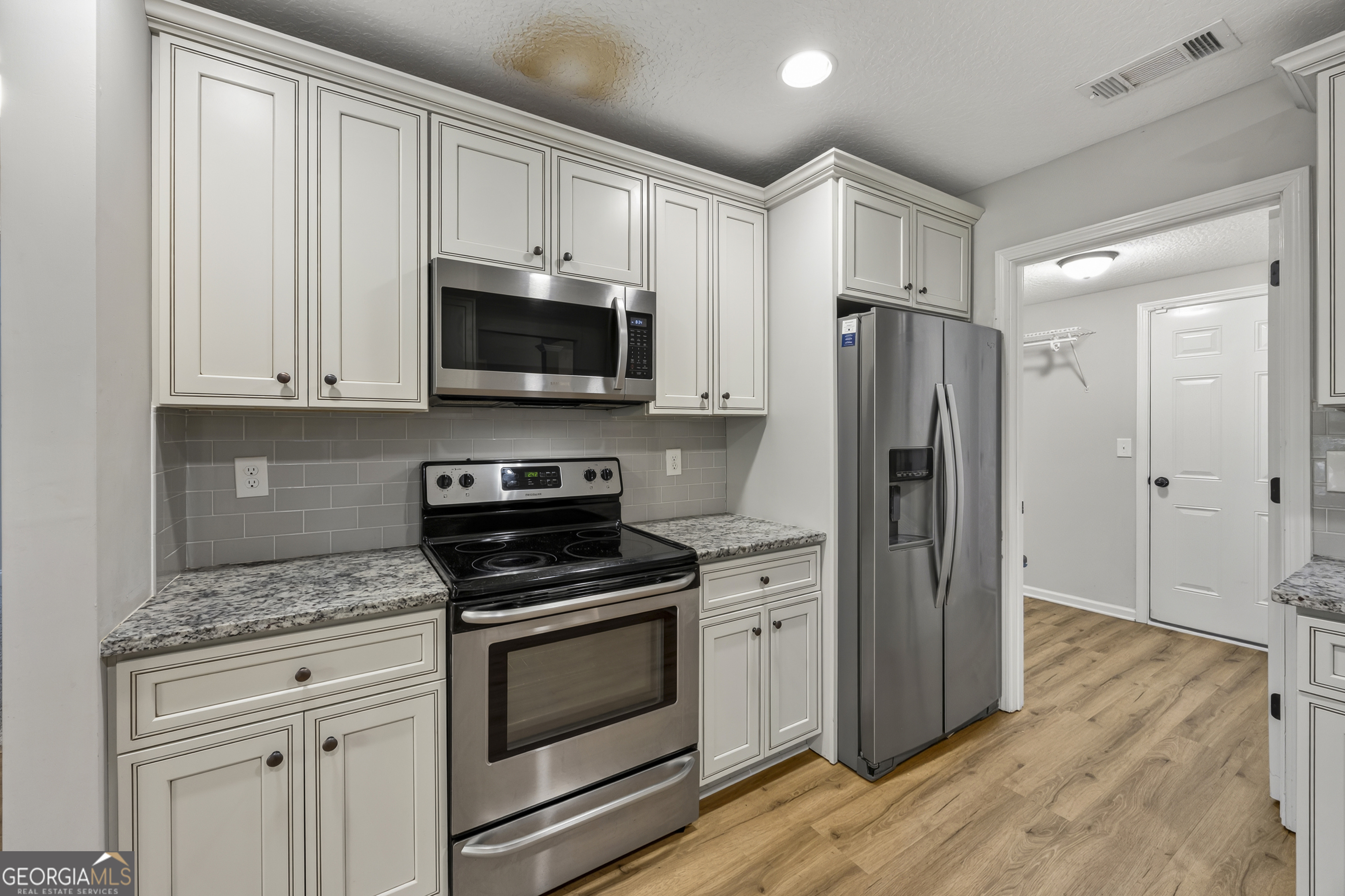 717 Oconee Lane Commerce, GA 30529 - Photo 30 of 57 a kitchen with granite countertop a refrigerator stove and microwave