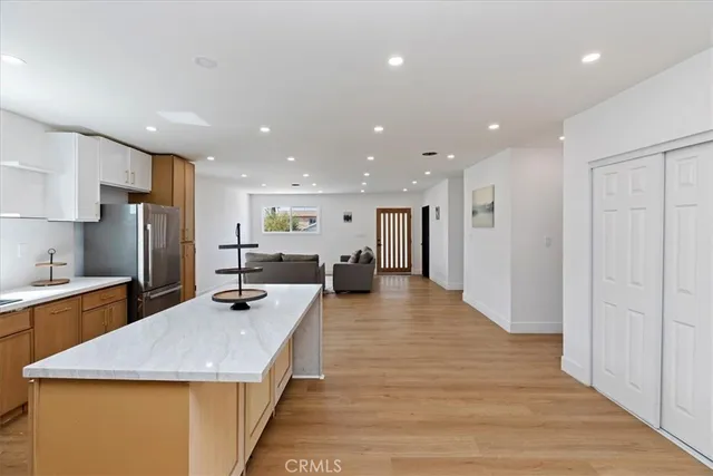 a large kitchen with stainless steel appliances lots of counter space and wooden floor