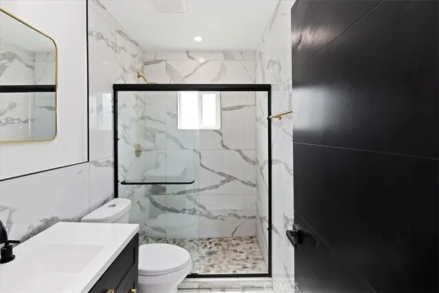 a bathroom with a toilet a sink and glass door