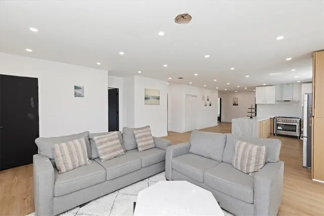 a living room with furniture kitchen area and a couch