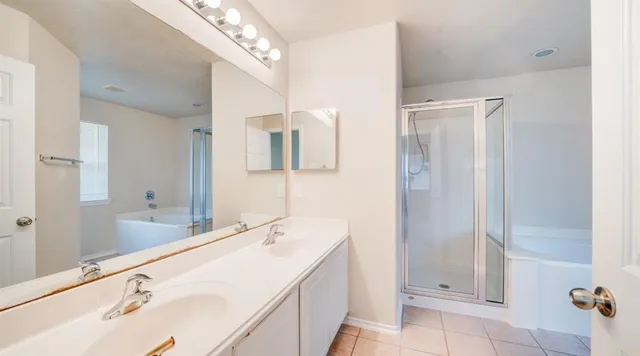 a bathroom with a double vanity sink mirror and shower