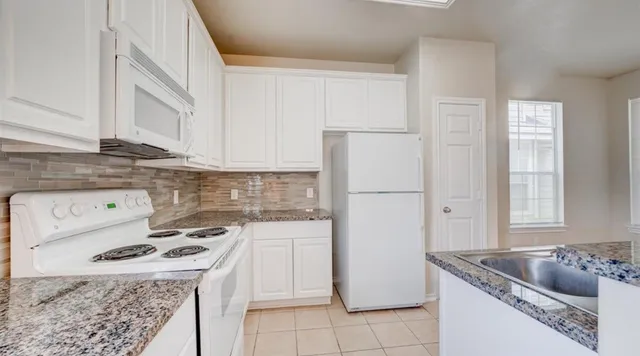a kitchen with a stove a refrigerator and a sink