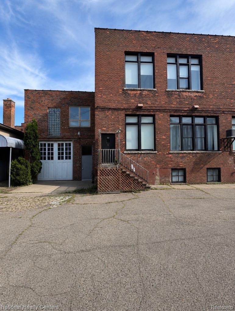 17 West Lawrence Street, Unit 2D Pontiac, MI 48342 - Photo 11 of 12 back/side private entrance. Permit parking available for this unit only. additional free parking lot in the front across the street