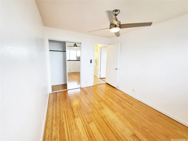 a view of empty room with wooden floor
