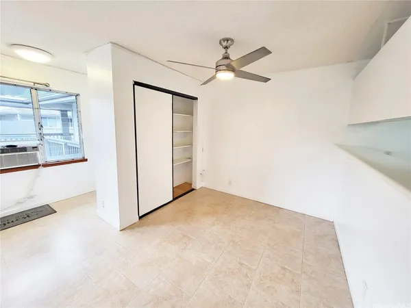 en empty room with windows and fan