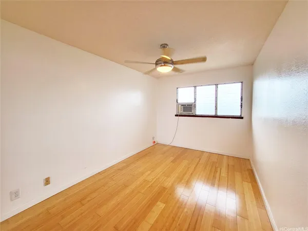 an empty room with a window and a ceiling fan