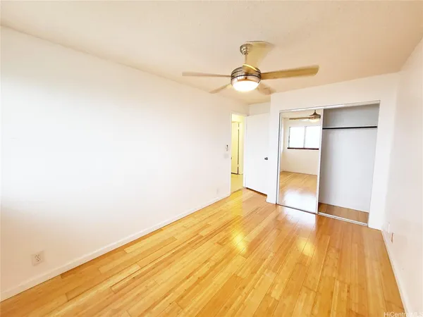 a view of empty room with wooden floor