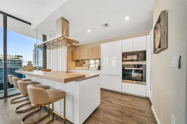 a kitchen with stainless steel appliances kitchen island granite countertop a stove and a refrigerator