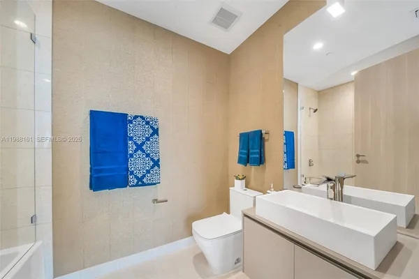 a bathroom with a sink mirror vanity and toilet