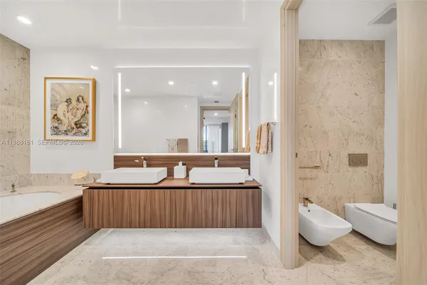 a bathroom with a tub sink and mirror