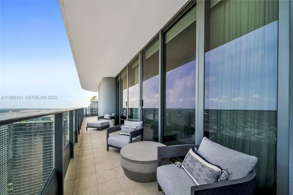 a balcony with furniture and a potted plant