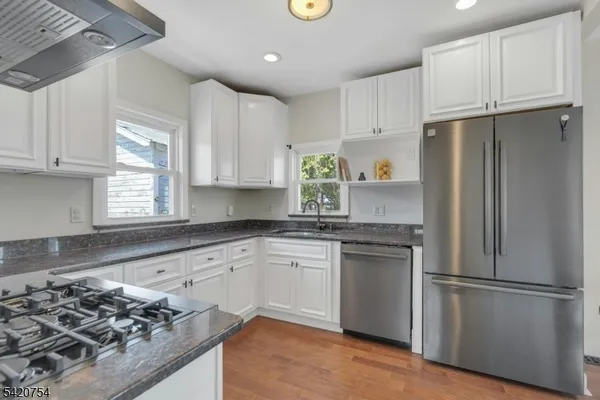 a kitchen with stainless steel appliances granite countertop a refrigerator sink and stove