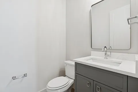 a bathroom with a sink a toilet and mirror