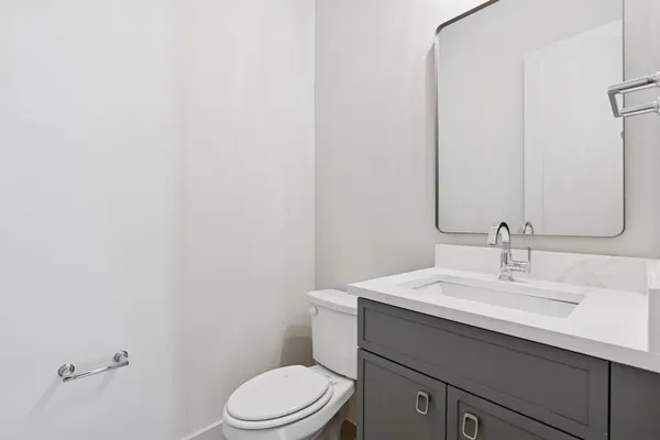 a bathroom with a sink a toilet and mirror