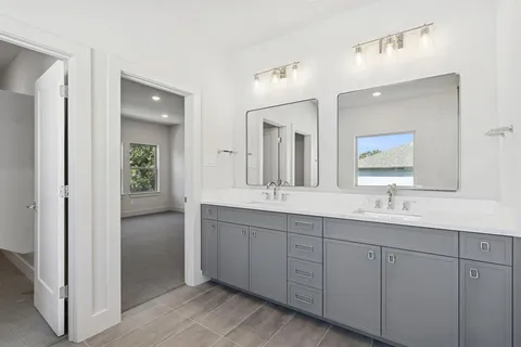 a bathroom with double sink and a mirror