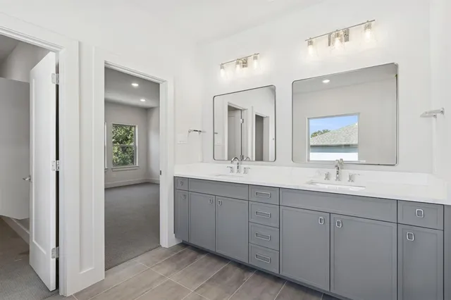 a bathroom with double sink and a mirror