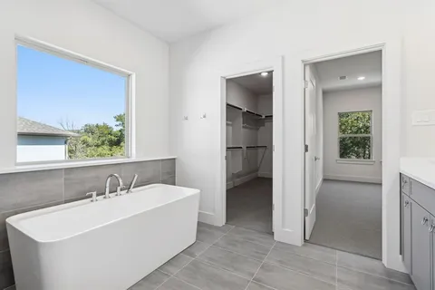 a white bath tub sitting next to a bathroom sink