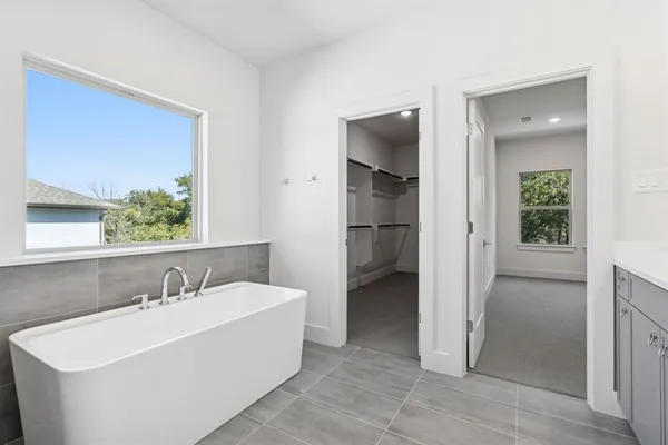 a white bath tub sitting next to a bathroom sink