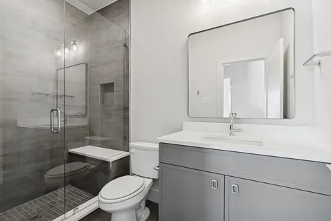 a bathroom with a sink toilet vanity and shower